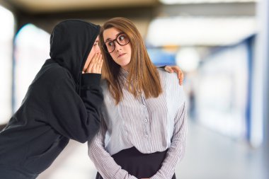 Ikiz kız fısıldamayı beyaz arka plan üzerinde  