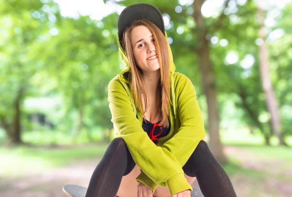 Hübsches junges Mädchen im urbanen Stil mit Skateboard — Stockfoto