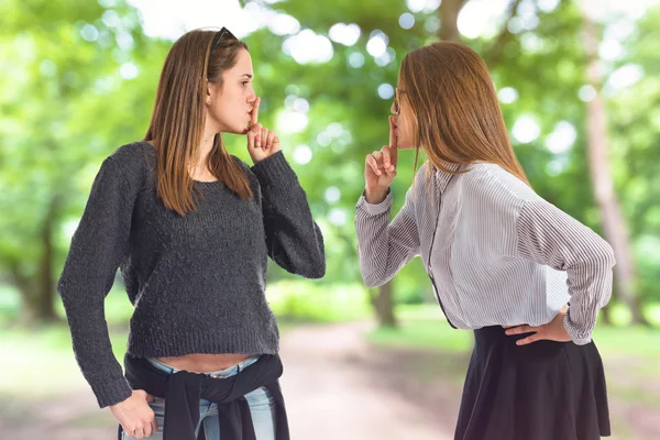 Twin sisters making silence gesture — Stock Photo, Image