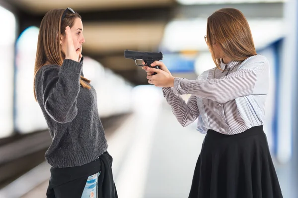 Teen girl pointing with a gun — Stock Photo, Image
