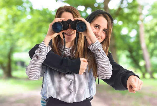 Tvillingsystrar med kikare — Stockfoto