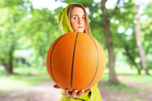 Menina loira jogando basquete sobre fundo branco — Fotografia de Stock