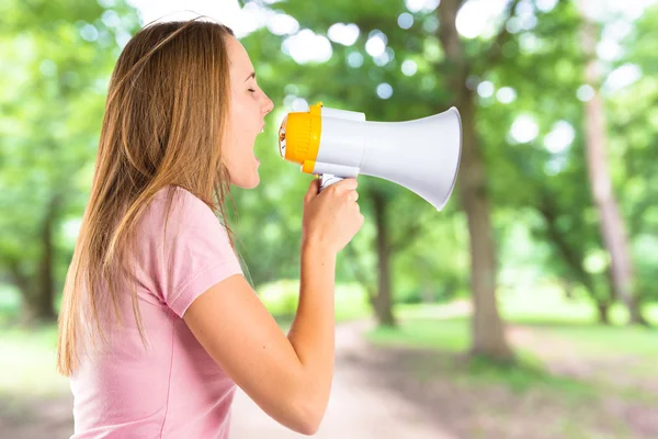Ragazza bionda urlando con un megafono su sfondo bianco — Foto Stock