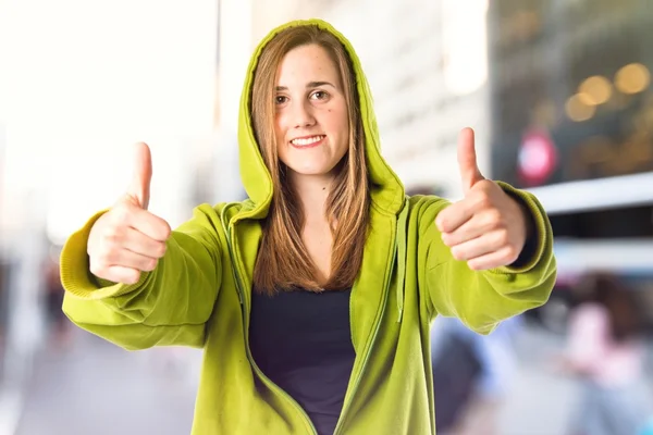 Chica bastante joven con pulgares arriba sobre fondo blanco — Foto de Stock