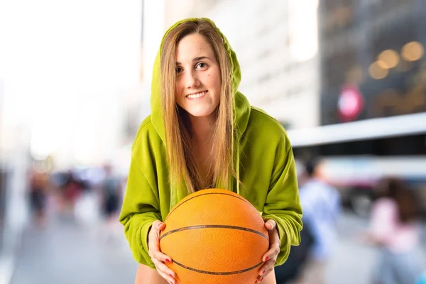 金发女孩打篮球，在白色的背景 — 图库照片