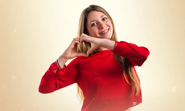 Tiener meisje maken een hart met haar handen — Stockfoto