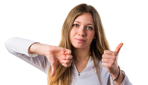 Giovanissima ragazza making buono-cattivo segno — Foto Stock