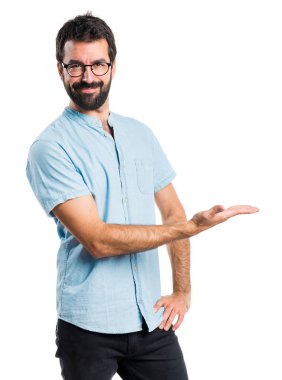 Mavi gözlüklü bir şey sunmak yakışıklı adam