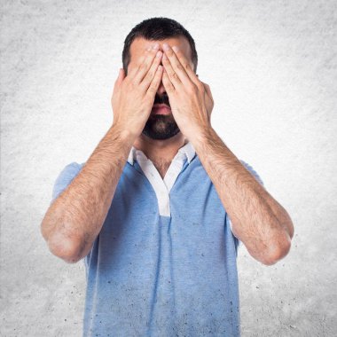 Adam gözlerini kapsayan mavi gömlek ile