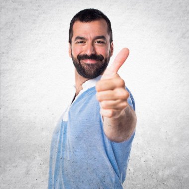 Başparmak ile mavi gömlekli adam