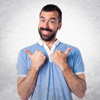 Başparmak ile mavi gömlekli adam