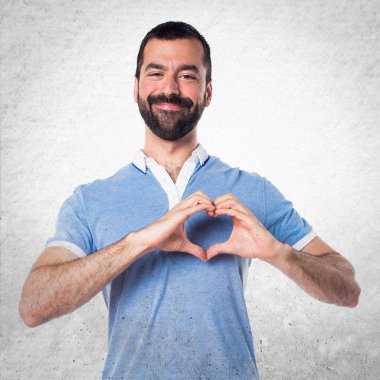 Adam mavi gömlek elleri ile bir kalp yapma