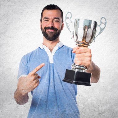 Mavi gömlekli bir kupa tutan adamla