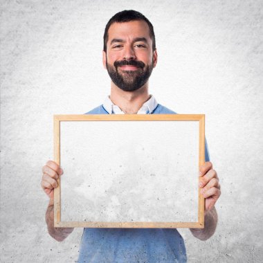 Mavi gömlek boş bir afişini tutan adamla