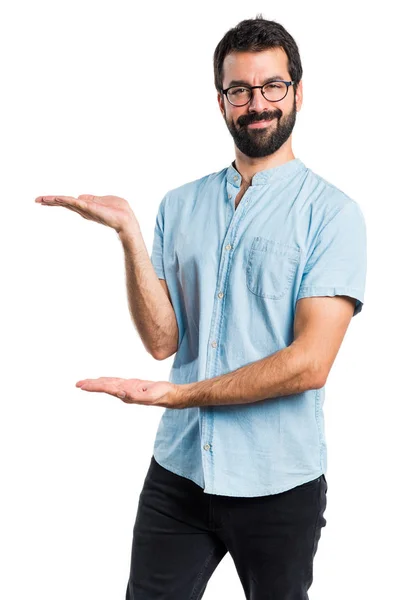 Homem bonito com óculos azuis apresentando algo — Fotografia de Stock