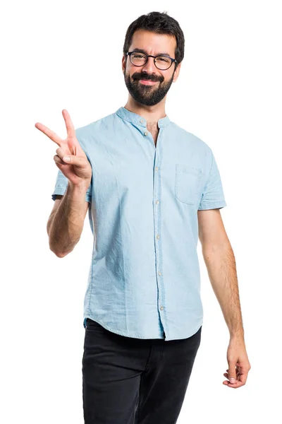 Hombre guapo con gafas azules haciendo gesto de victoria — Foto de Stock