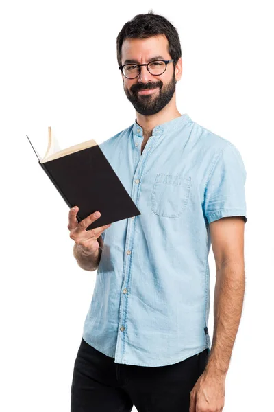 Schöner Mann mit blauer Brille liest Buch — Stockfoto