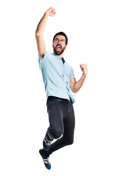 Bonito homem com óculos azuis pulando — Fotografia de Stock