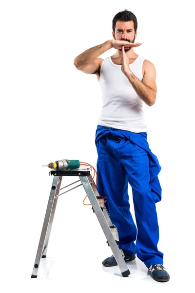 Young electrical technician with a drill making time out gesture — Stock Photo, Image