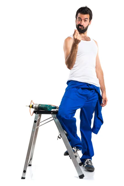 Young electrical technician with a drill making money gesture — Stock Photo, Image