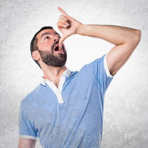 Homem com camisa azul fazendo gesto bêbado — Fotografia de Stock