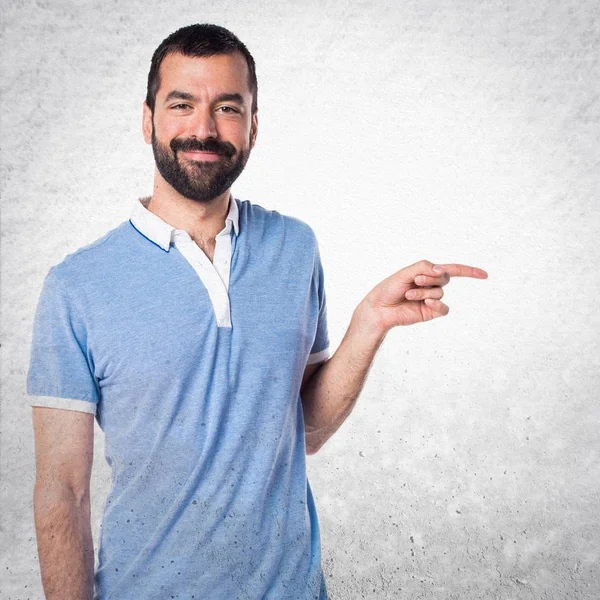 Hombre con camisa azul apuntando hacia el lateral —  Fotos de Stock