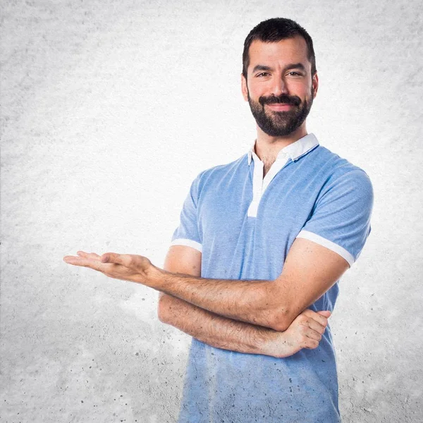 Hombre con camisa azul presentando algo — Foto de Stock