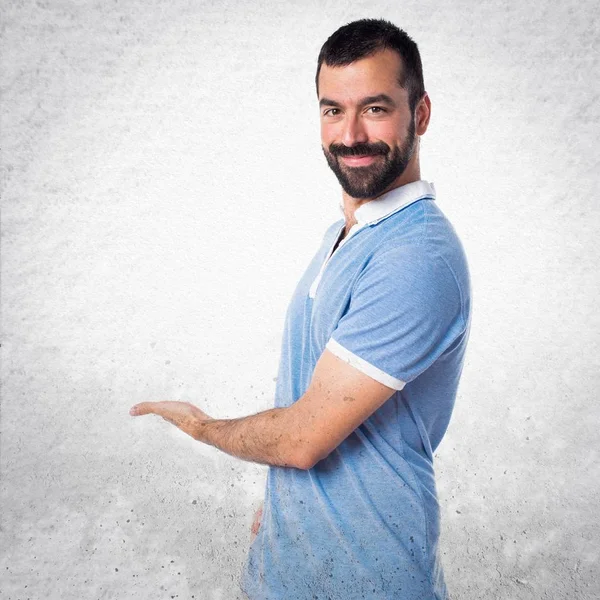 Adam bir şey sunmak mavi gömlek ile — Stok fotoğraf