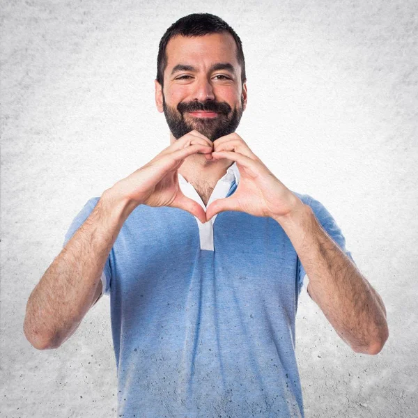 Άνδρας με μπλε πουκάμισο κάνοντας μια καρδιά με τα χέρια του — Φωτογραφία Αρχείου