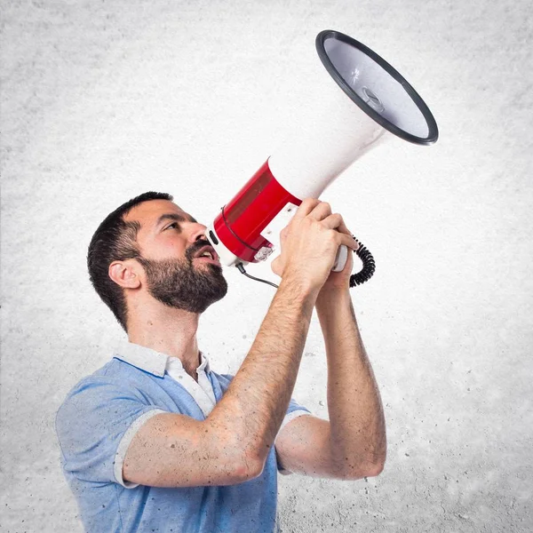 Man with blue shirt shouting by megaphone — Stock Photo, Image