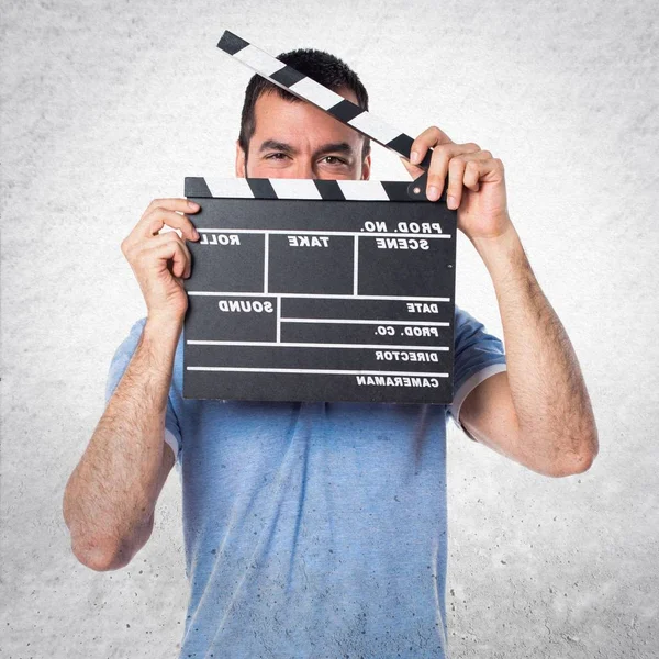 Uomo con camicia blu con un clapperboard — Foto Stock