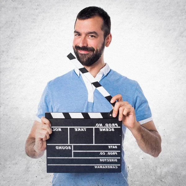 Hombre con camisa azul sosteniendo una tabla de aplausos —  Fotos de Stock