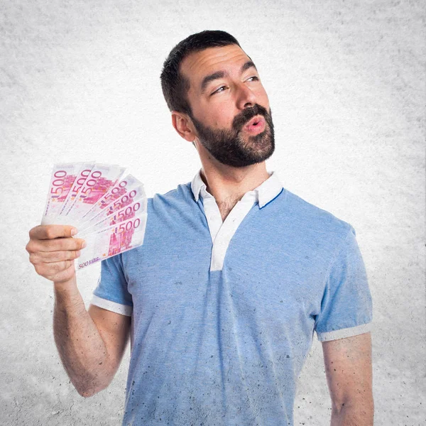 Hombre con camisa azul tomando un montón de dinero — Foto de Stock