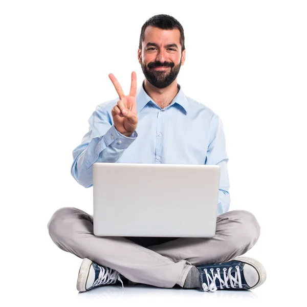 Homem com laptop contando dois — Fotografia de Stock