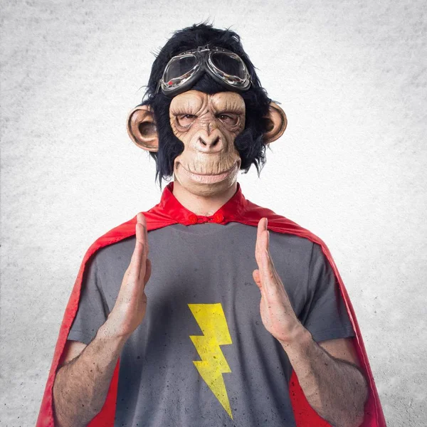 Superhéroe mono hombre sosteniendo algo —  Fotos de Stock