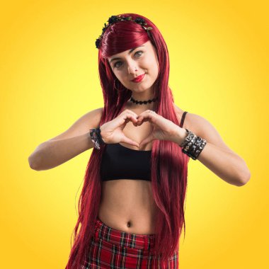 Genç Kızıl saçlı kız elleri ile bir kalp yapma