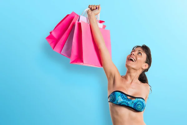 Frau im Bikini mit vielen Einkaufstüten — Stockfoto