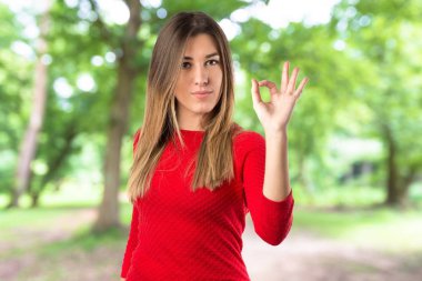 Genç kadın Tamam beyaz arka plan üzerinde kayıt yapma 