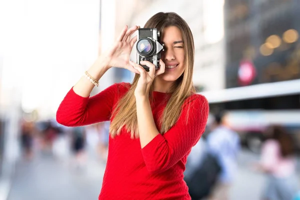 Menina tirando uma foto sobre fundo branco — Fotografia de Stock