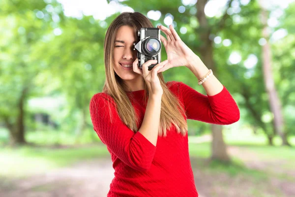 Menina tirando uma foto sobre fundo branco — Fotografia de Stock