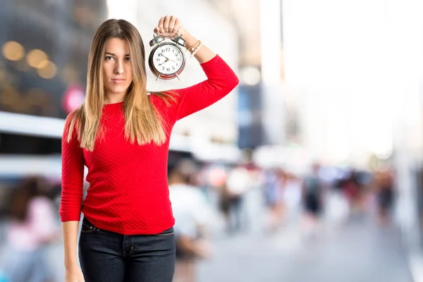 Молодая девушка держит антикварные часы на белом фоне — стоковое фото