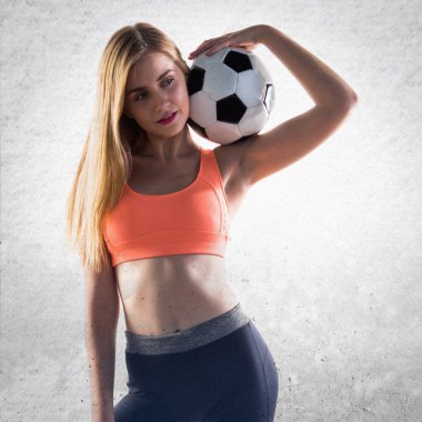 Bir futbol topu tutan güzel sarışın kız