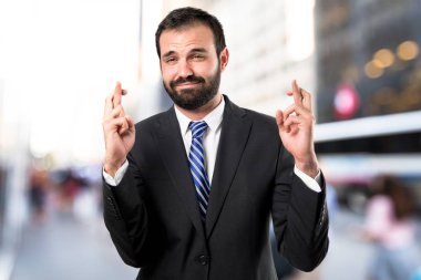 onun parmaklarını çaprazlanarak beyaz arka plan ile genç işadamı