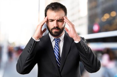 Beyaz arka plan üzerinde baş ağrısı ile genç işadamı 