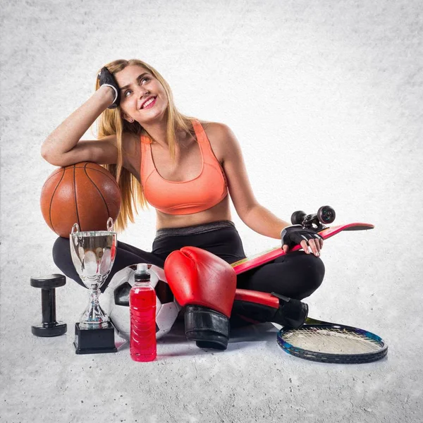 Спортивная девушка с большим количеством спортивных предметов — стоковое фото