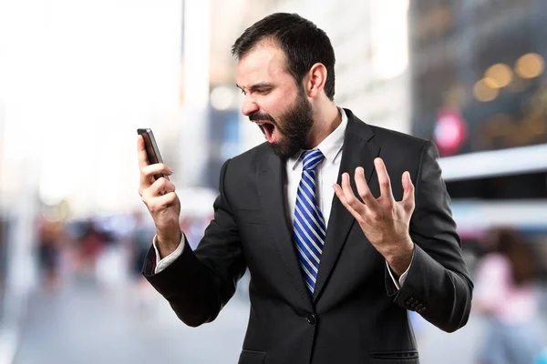 Νέους επιχειρηματίες φωνάζοντας σε κινητό πέρα από το απομονωμένο υπόβαθρο. — Φωτογραφία Αρχείου
