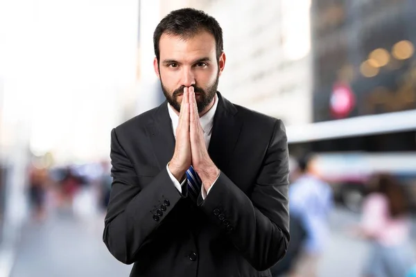 Junger Geschäftsmann fleht vor weißem Hintergrund — Stockfoto