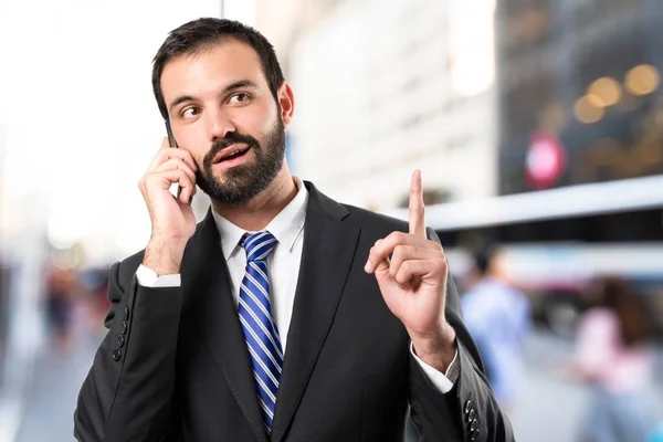 Jóvenes hombres de negocios hablando con móviles sobre un fondo aislado . —  Fotos de Stock