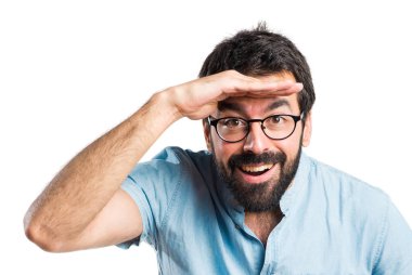 Bir şey gösterilen mavi gözlüklü yakışıklı adam