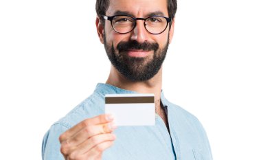Bir kredi kartı tutan mavi gözlüklü yakışıklı adam